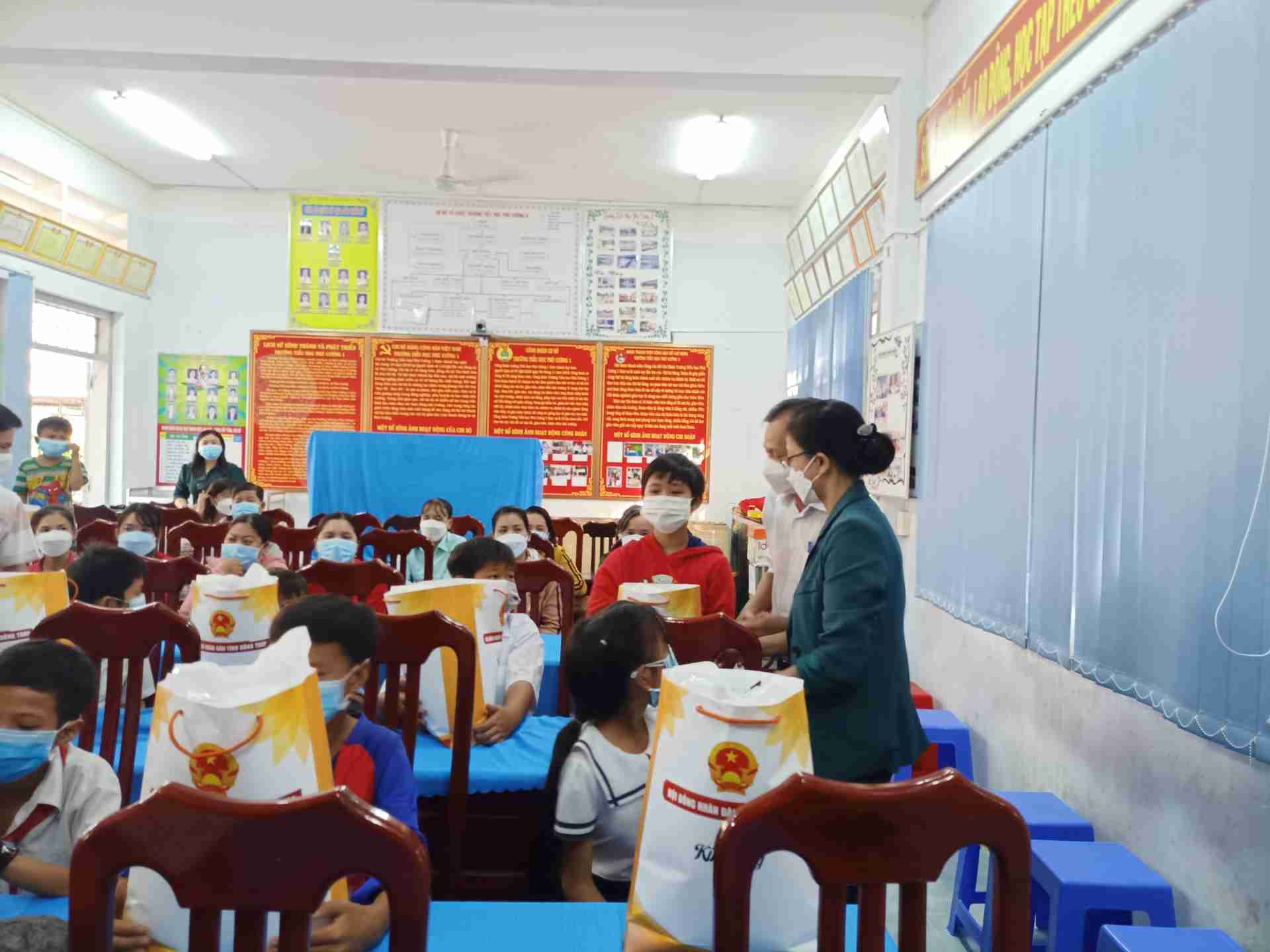 Các em học sinh được Bà Tuyến và đại diện Phòng Giáo dục – Đào tạo tận tay trao quà